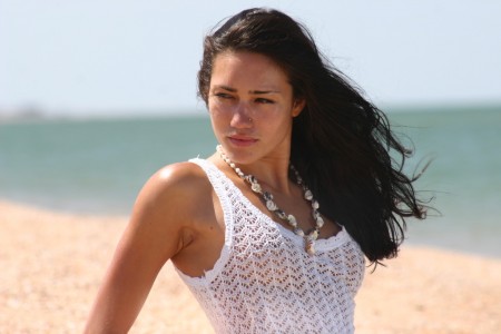 Black-haired  in a white dress on the beach