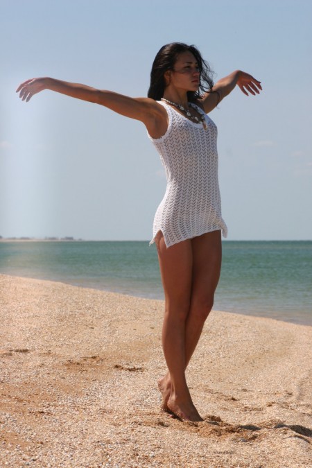 Black-haired  in a white dress on the beach