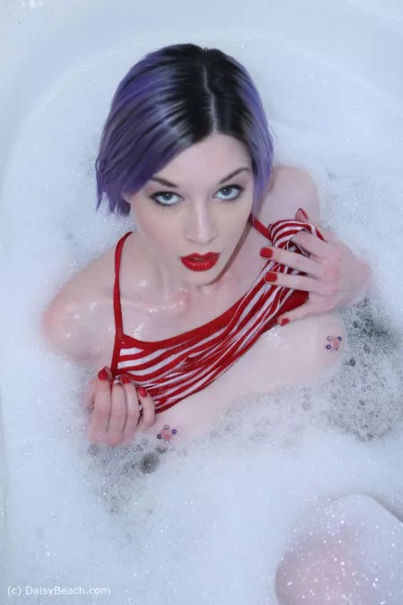 Babe takes a bubble bath and strokes her pussy